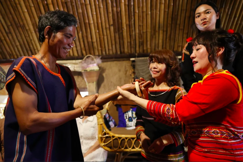 Домовладельца Х'Кьяп Ниэ дарит браслеты участникам церемонии. Фото: Туан Ань/ВИА