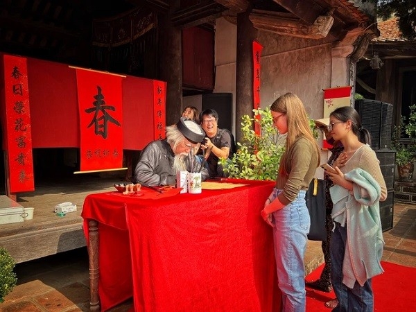 - Иностранные гости интересуются вьетнамским обычаем написания иероглифа в начале нового года. Фото: Май Май/Вьетнам+.