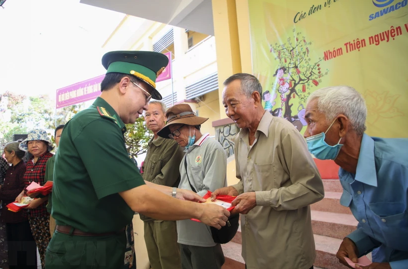 Подполковник Фам Динь Чиеу, политкомиссар Пограничных войск Тайнинь, вручает подарки жителям приграничного района. (Фото: Жанг Фыонг/ВНА)