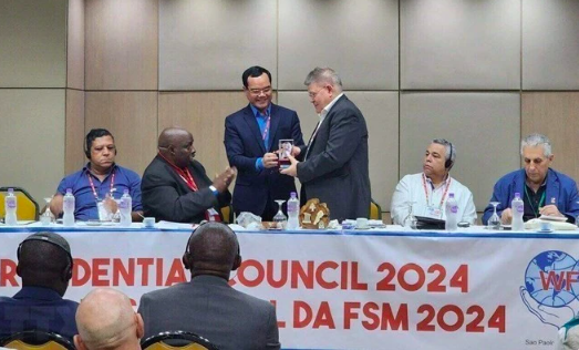 Председатель Всеобщей конфедерации труда Вьетнама Нгуен Динь Кханг вручает сувенир делегатам Совета президентов Всемирной конфедерации профсоюзов. Фото: ВИА
