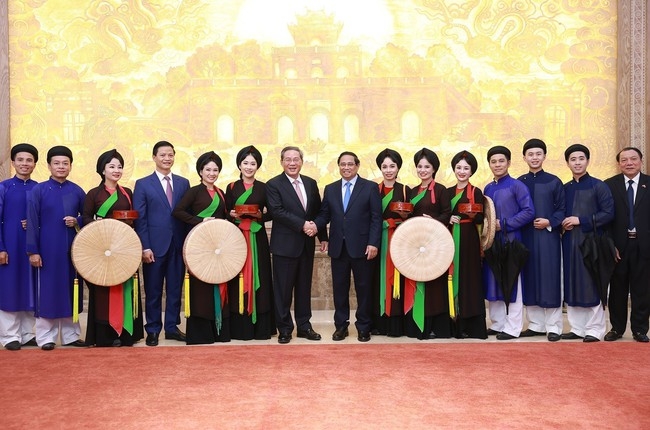 Премьер-министр Вьетнама Фам Минь Тинь и премьер-министр Китая Ли Цянь с народными артистами провинции Бакнинь. Фото: Зыонг Жанг / ВИА
