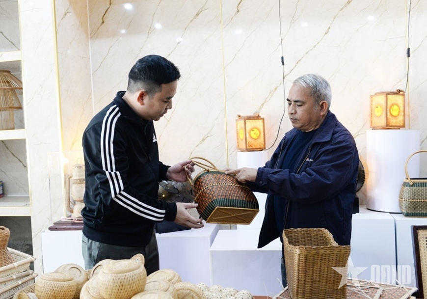 Народный мастер Нгуен Ван Тинь (справа) представляет изделия художественного плетения из бамбука и ротанга.