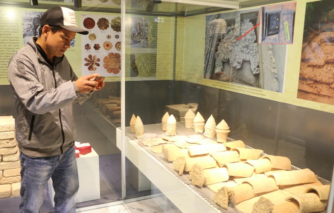 Посетители с помощью смартфона изучают информацию и ценности экспонатов, представленных в Выставочном доме культуры Окео (Анзянг).