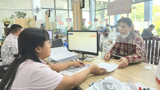 Сотрудница Центра административных услуг квартала Анфулонг, Хошимин, инструктирует жителя по выполнению административных процедур. Фото: НГО БИНЬ