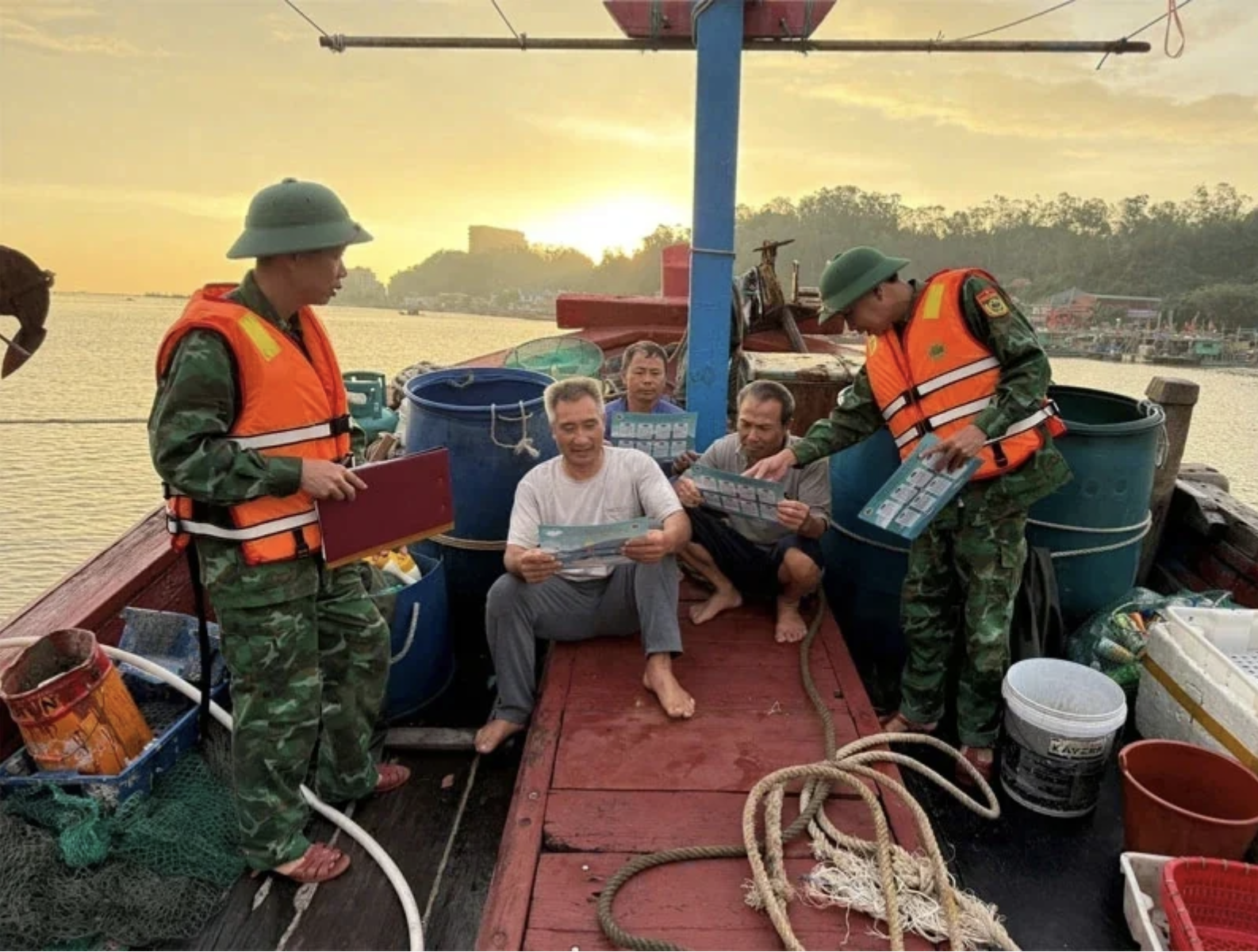 Офицеры и солдаты пограничного поста Хоанг Чыонг, коммуна Хоанг Тьен (Тхань Хоа) распространяют среди рыбаков в районе правил подразделения управления по предотвращению и контролю за эксплуатацией НПО. (Фото: Дэн Вьет)