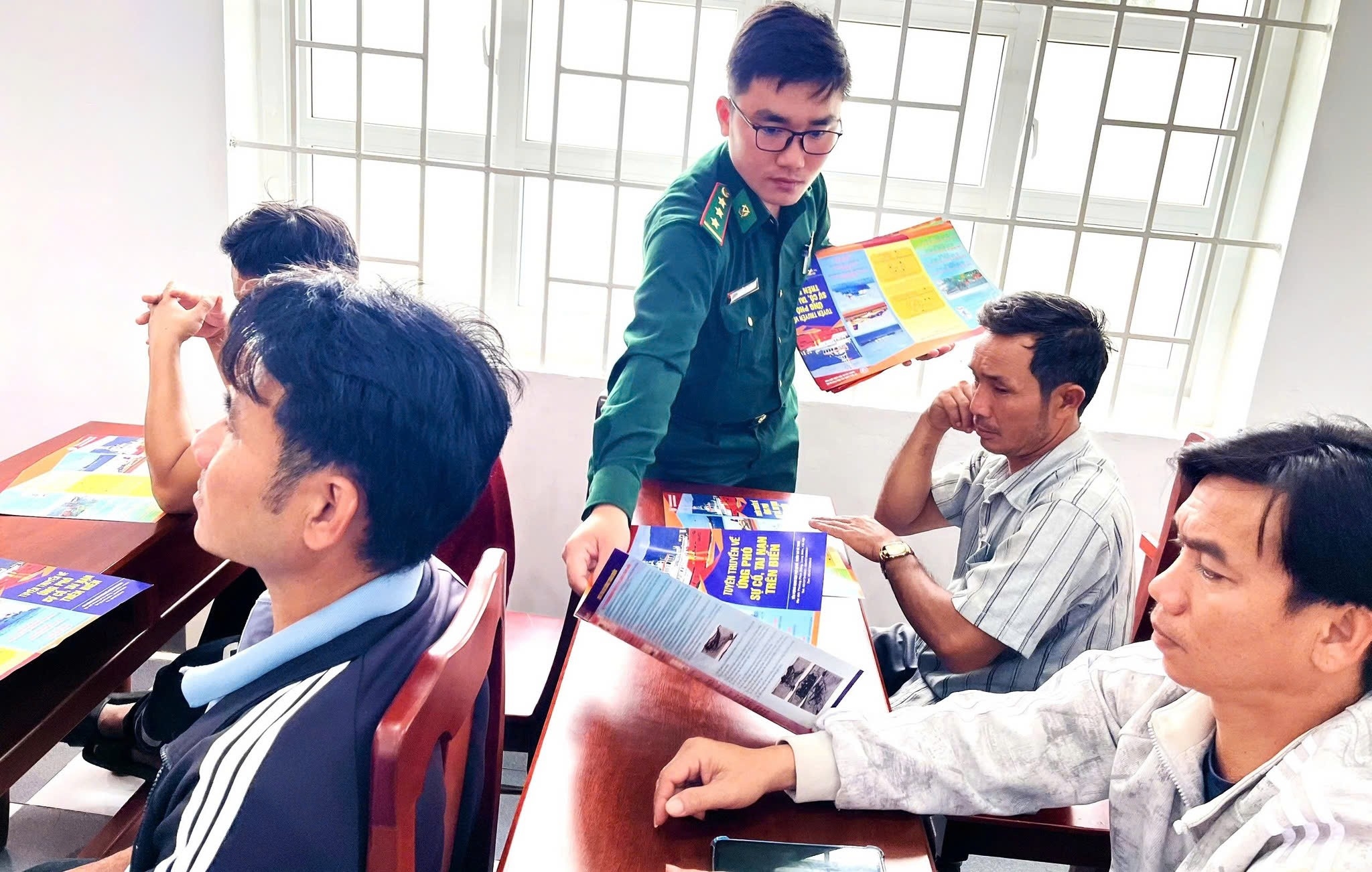 Сотрудники пограничной службы Цинхая распространяют среди рыбаков положения закона, касающиеся рыболовной деятельности. (Фото: Пограничная служба Кханьхоа)