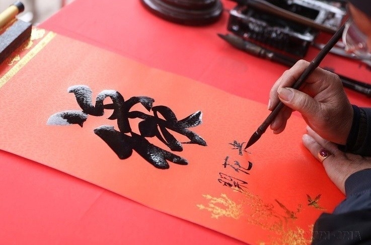 Написание каллиграфических слов в первые дни Нового года - традиция вьетнамской культуры